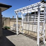 This painted white pergola is set at the back of the residence to provide further depth and added green space once the Pergola has had a flowering vine added.