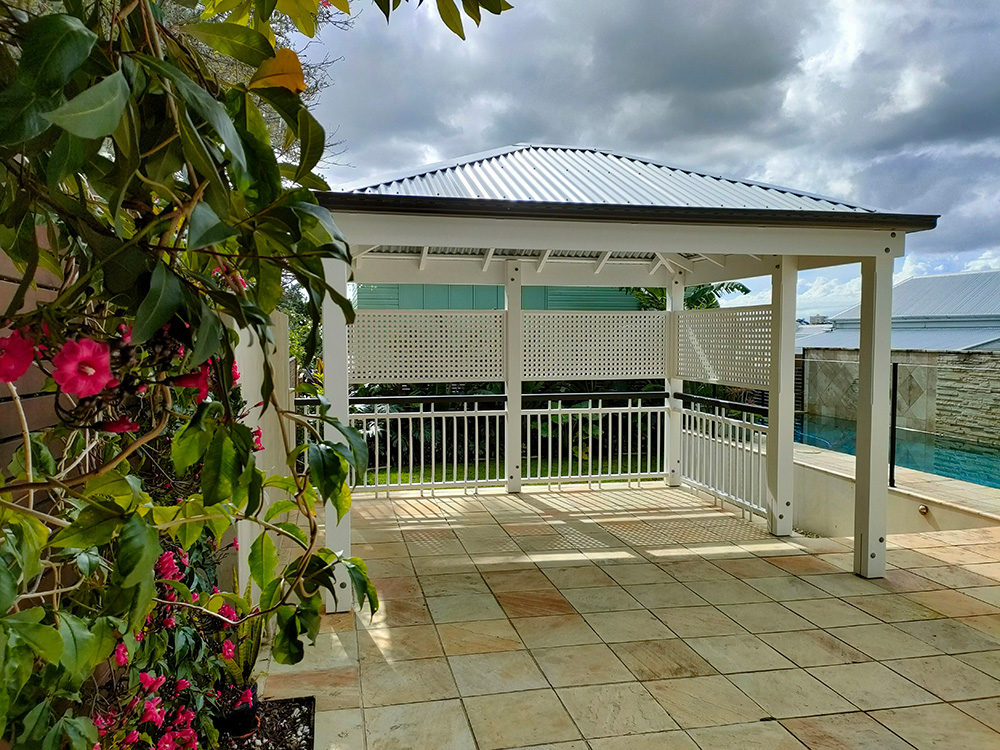 This painted Pine Gazebo includes 6 posts that frame the raised pool surround near the stairs. The new handrail provides a safe new area for the young family at this residence.