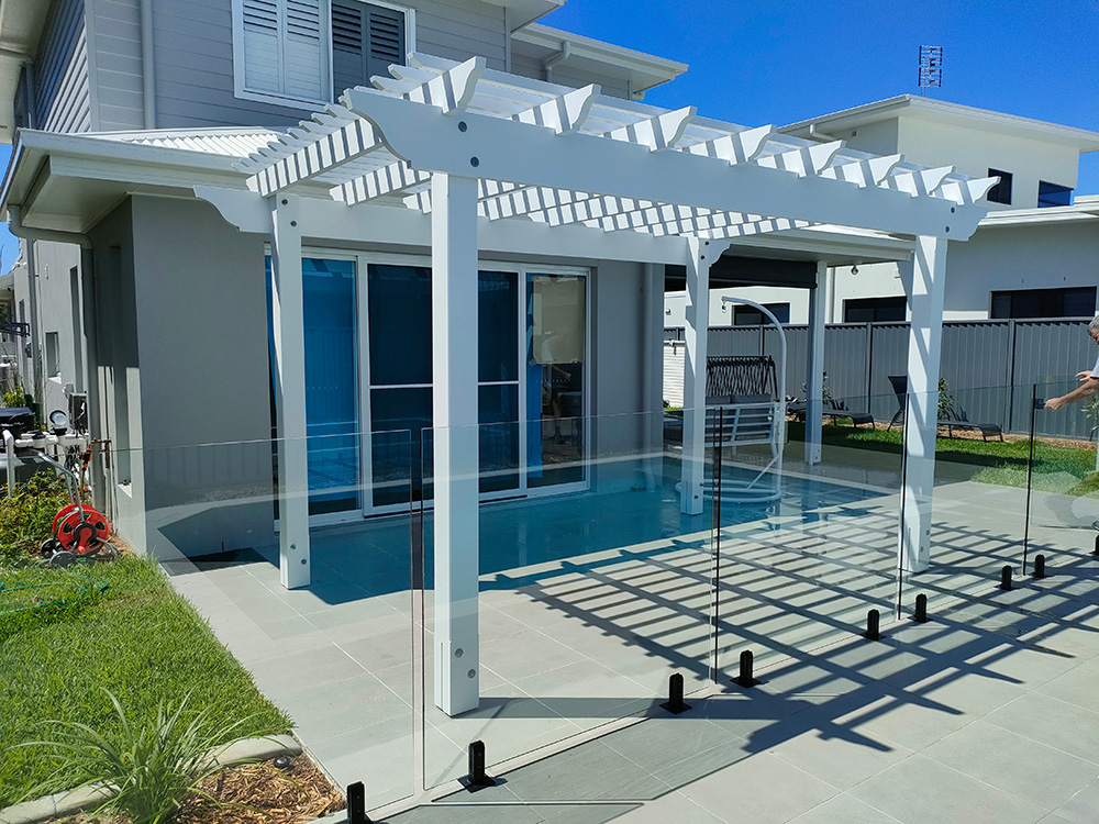 This beautiful White Pergola with the decorative OGEE profile has been set outside a living room. The Pergola will provide additional shade for this room.